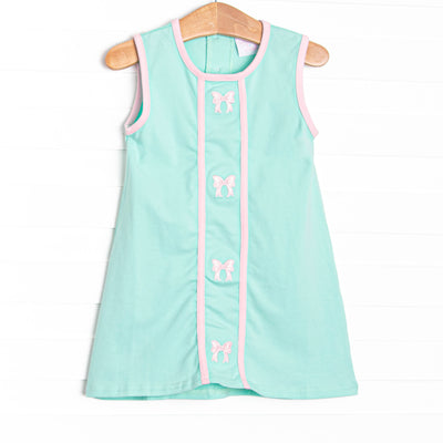 This dress features a mint green knit material, pink trim, and pink bows embroidery