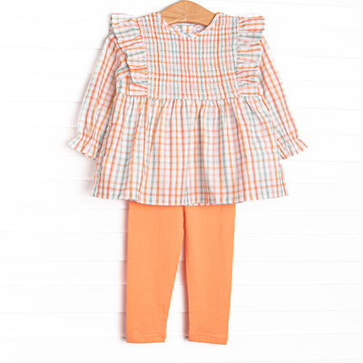 This set features an orange plaid print, ruffle trim, and coordinating orange leggings to match.