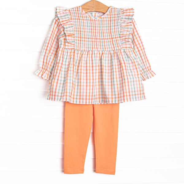 This set features an orange plaid print, ruffle trim, and coordinating orange leggings to match.