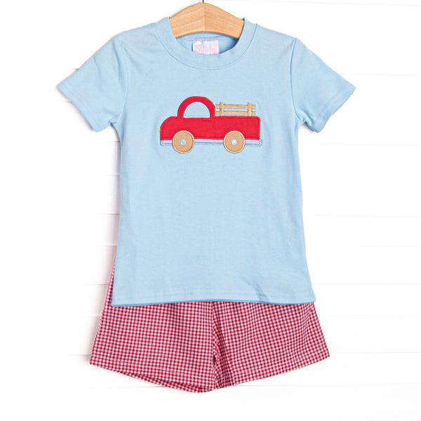 This set features a blue short sleeve top with a red truck applique and red gingham shorts to match.