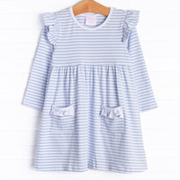  The dress features front ruffle pockets, white trim, and soft knit material. 