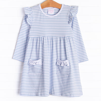  The dress features front ruffle pockets, white trim, and soft knit material. 