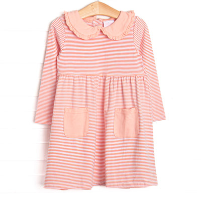This dress features a peach stripes, front pockets, and a peter pan collar with ruffle trim.