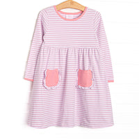 The dress features front ruffle pockets, light pink trim, light purple stripes. 