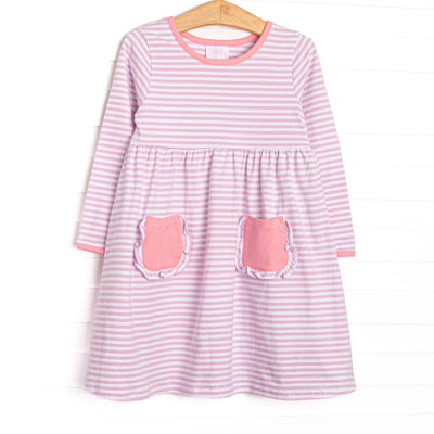  The dress features front ruffle pockets, light pink trim, light purple stripes. 