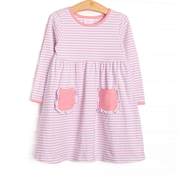  The dress features front ruffle pockets, light pink trim, light purple stripes. 