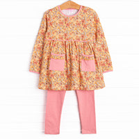  This set features a yellow floral print, pockets to keep little hands warm, and pink leggings to match. 