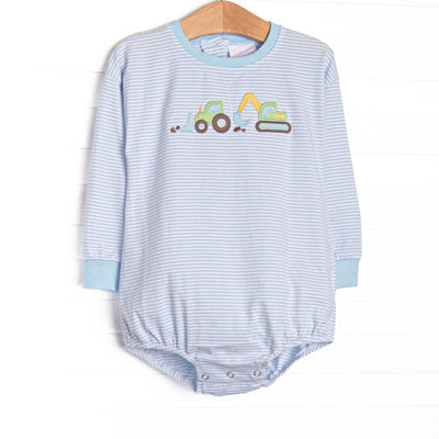 This bubble features a blue striped top, dig machines applique, and long sleeves.