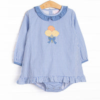 This skirted bubble features a blue gingham fabric, a blue ruffle collar, and a mum applique. 