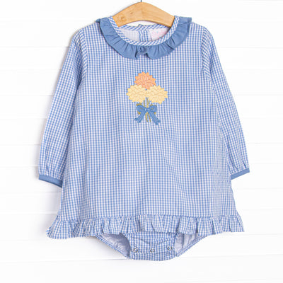  This skirted bubble features a blue gingham fabric, a blue ruffle collar, and a mum applique. 