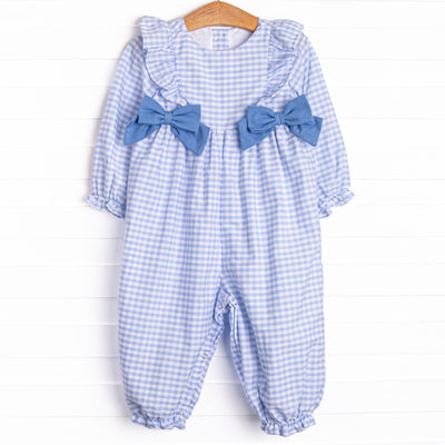  This romper features a blue gingham print, blue bows and ruffle trim. 
