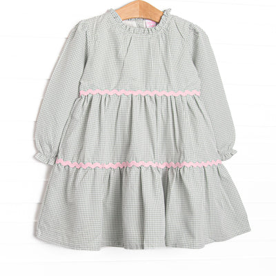  This dress features a sage gingham print, pink ric rac trim, and button closure on the back. 