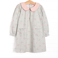 This dress features green stripes, a pink floral print, a peach Peter Pan collar, and front pockets.