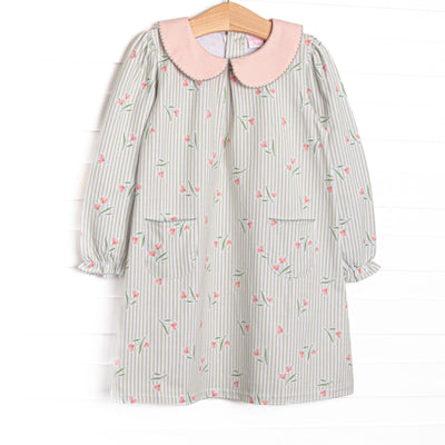 This dress features green stripes, a pink floral print, a peach Peter Pan collar, and front pockets.