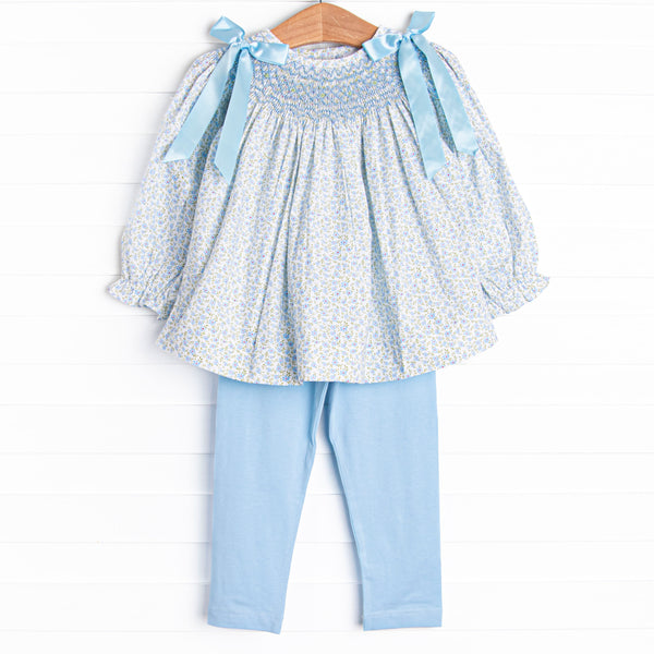A long sleeve top with a blue smocking and blue bow details on the shoulders. Coordinating blue leggings to match.