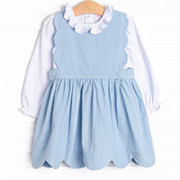 This set features a long sleeve top with a ruffle collar and a blue corduroy jumper with a scalloped edge.
