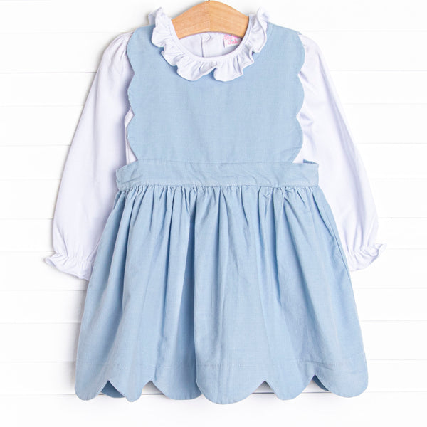 This set features a long sleeve top with a ruffle collar and a blue corduroy jumper with a scalloped edge.