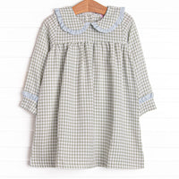 This dress is featured in a green gingham print, with a peter pan collar with a blue ruffle detail.