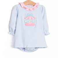 This skirted bubble features blue striped fabric, a pink ruffle collar, and a carousel applique. 
