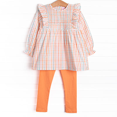  This set features an orange plaid print, ruffle trim, and coordinating orange leggings to match. 