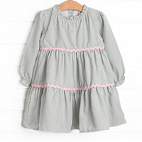 This dress features a sage gingham print, pink ric rac trim, and button closure on the back.