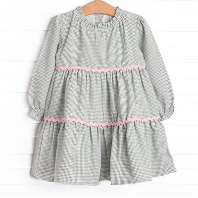 This dress features a sage gingham print, pink ric rac trim, and button closure on the back.
