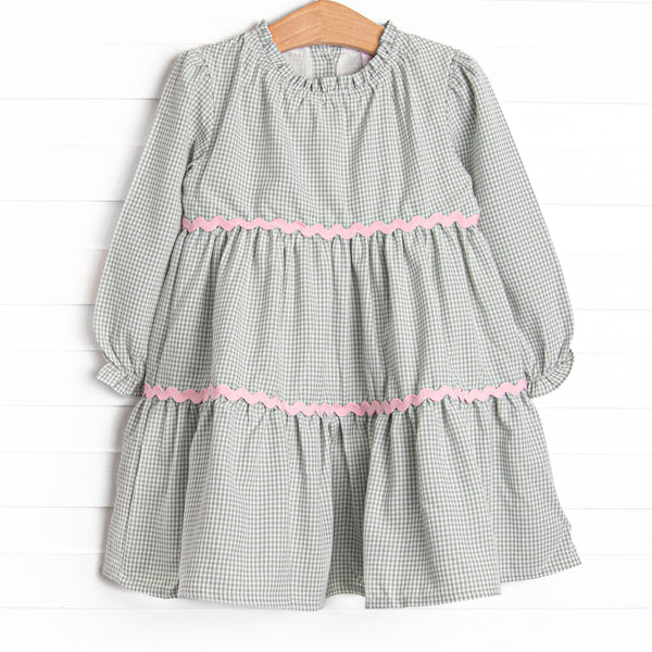 This dress features a sage gingham print, pink ric rac trim, and button closure on the back.