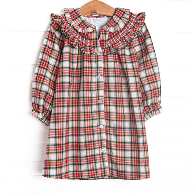 This dress features a red tartan fabric, dainty smocking, and beautiful ruffle trimmed Peter Pan collar.