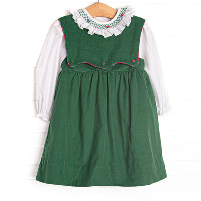 This dress features a green corduroy fabric, a button on bib, and white long sleeve top with a smocked scalloped collar
