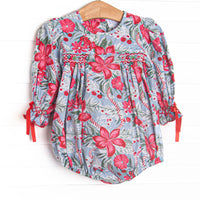  This bubble features a blue floral fabric, dainty smocking, and ribbon sleeve ties. 