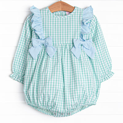  This bubble features a mint green gingham print, snaps on the stride, and blue ruffles and bows. 