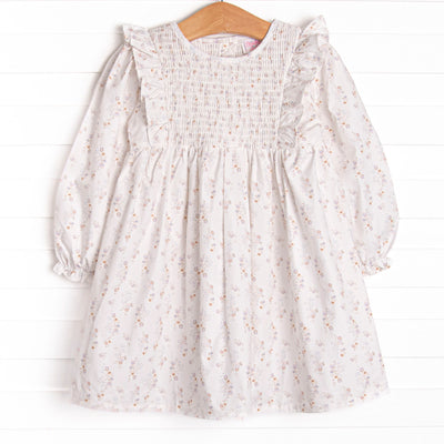 This dress features a blue floral print, a dainty smocking, and flutter trim.