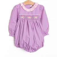  This bubble features purple gingham fabric, floral smocking, and a light pink ruffle collar. 