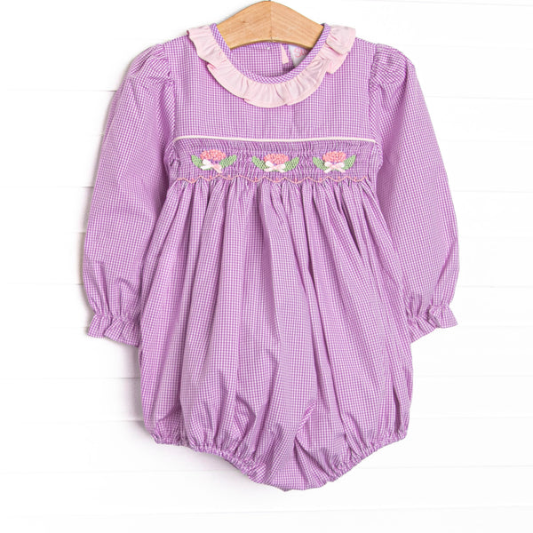  This bubble features purple gingham fabric, floral smocking, and a light pink ruffle collar. 