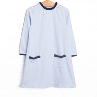 This dress features light blue stripes, front pockets, and navy ruffle trim.