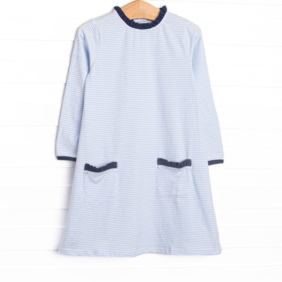 This dress features light blue stripes, front pockets, and navy ruffle trim.