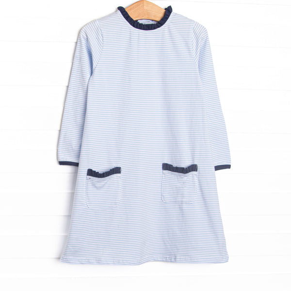 This dress features light blue stripes, front pockets, and navy ruffle trim.