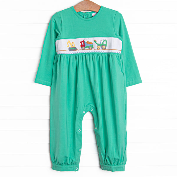  This romper features green knit material, snaps on the stride, and&nbsp; a construction themed smocking. 