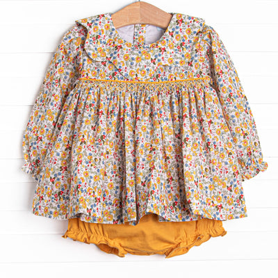 This set features a yellow floral print, a scalloped collar, and a dainty smocking. Coordinating yellow diaper cover to match.