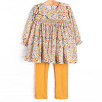  This set features a yellow floral print, a scalloped collar, and a dainty smocking. Coordinating yellow leggings to match. 