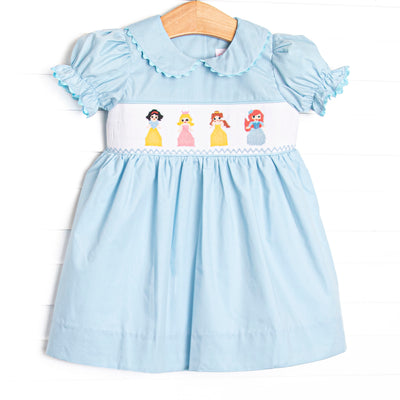 This dress is featured in a blue and white mini gingham, puff sleeves, rick rack trim, and a smocking of precious princesses!