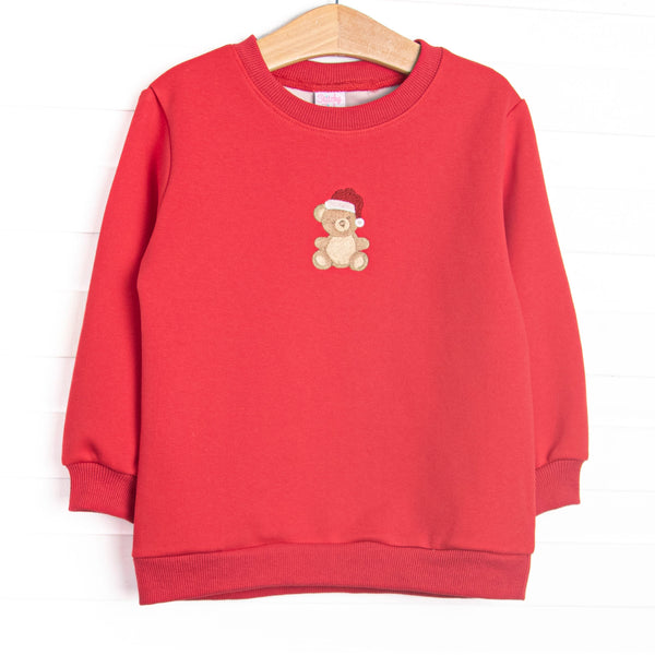 This top features red fleece material, a teddy bear embroidery, and long sleeves.