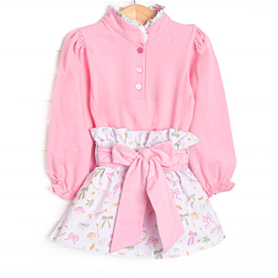 This set features a pink buttoned top, a ruffle neck, and a leaves and bows printed skirt with a tied waist.