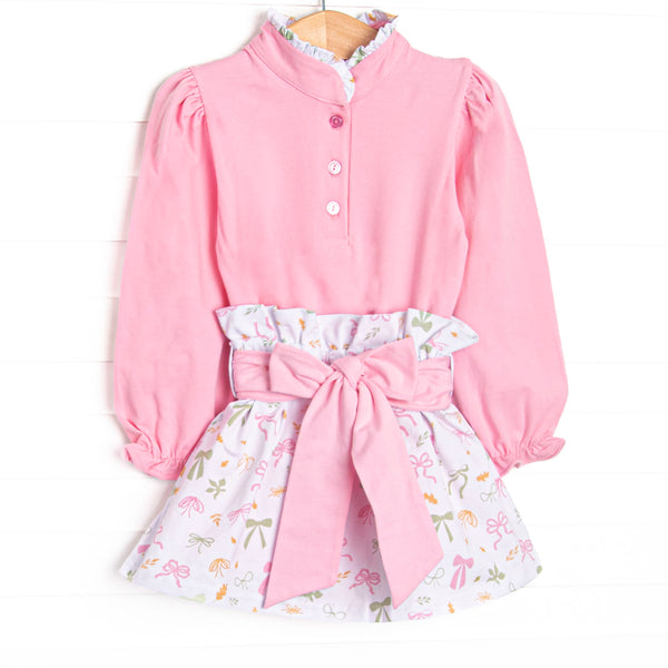 This set features a pink buttoned top, a ruffle neck, and a leaves and bows printed skirt with a tied waist.