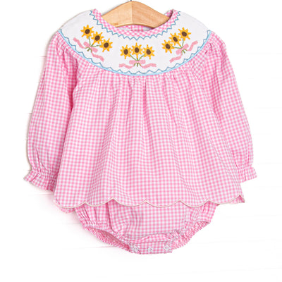  This skirted bubble features pink gingham fabric, sunflower smocking, and scallop trim. 