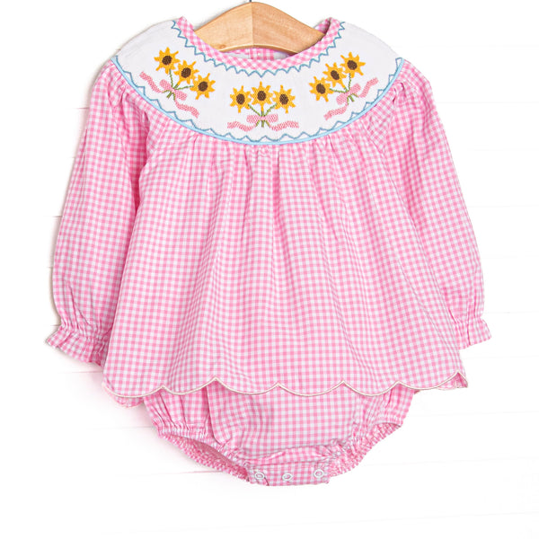  This skirted bubble features pink gingham fabric, sunflower smocking, and scallop trim. 
