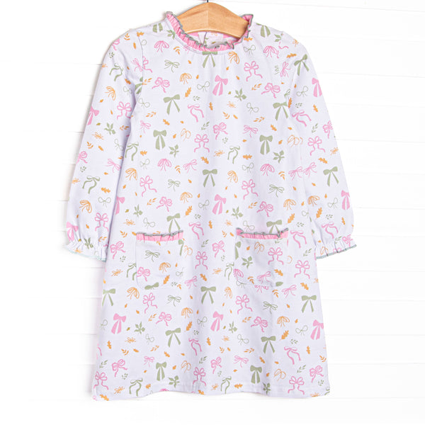  This dress features a leaves and bows print, a ruffle neck, and ruffle front pockets. 