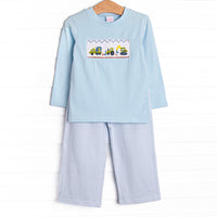  This set features a blue top with a construction truck smocking and blue striped pants to match. 