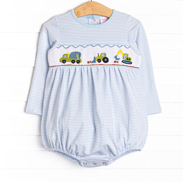 This bubble features a blue striped print, snaps on the stride, and a construction truck smocking.