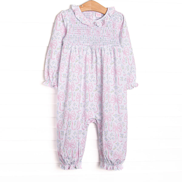 This romper features a floral and bow print, a ruffle collar, and chest smocking.